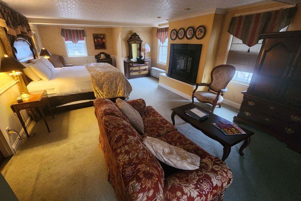 Marshall's Library: four-poster bed with dark wood wardrobe and black fireplace