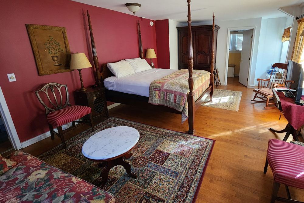 Rebecca's Retreat: four-poster bed with patchwork quilt and round marble table