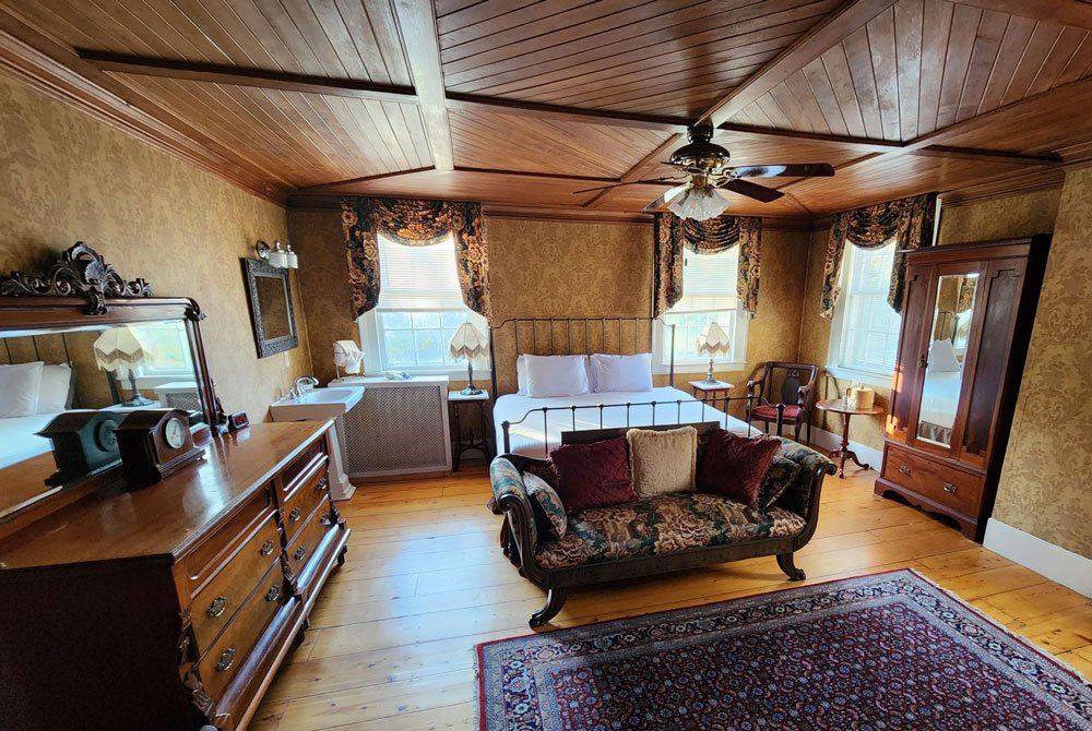 Martin Chester's Room: iron bedstead under a wood-paneled ceiling