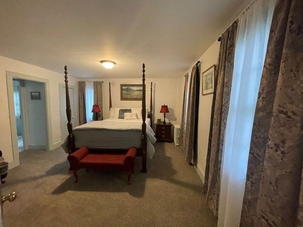 Zadock Hard's Room: four-poster bed with twin red-shaded bedside lamps